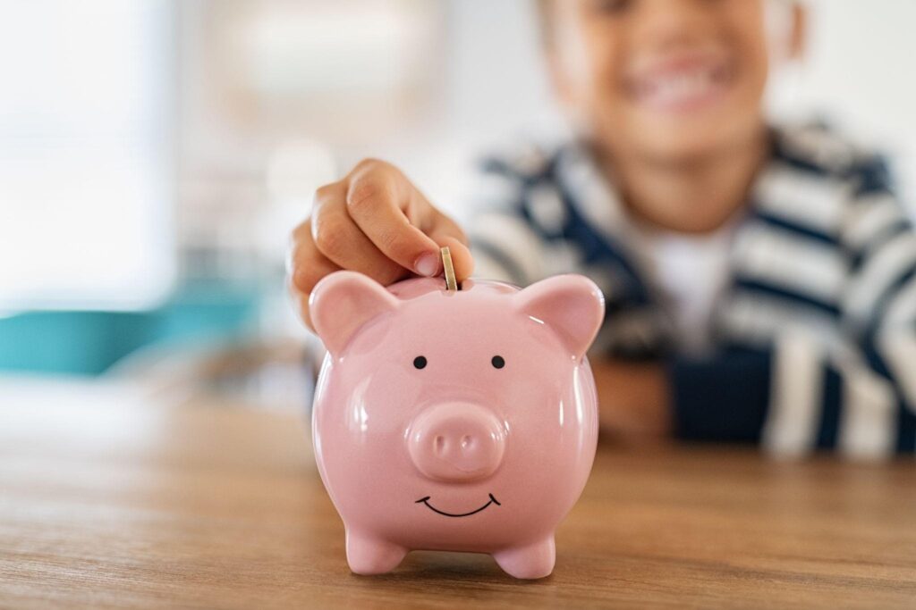 A child puts a coin in a piggy bank